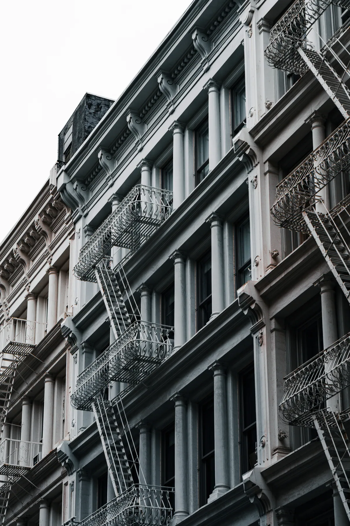 Fire escapes and repeated windows on a facade in Manhattan, New York