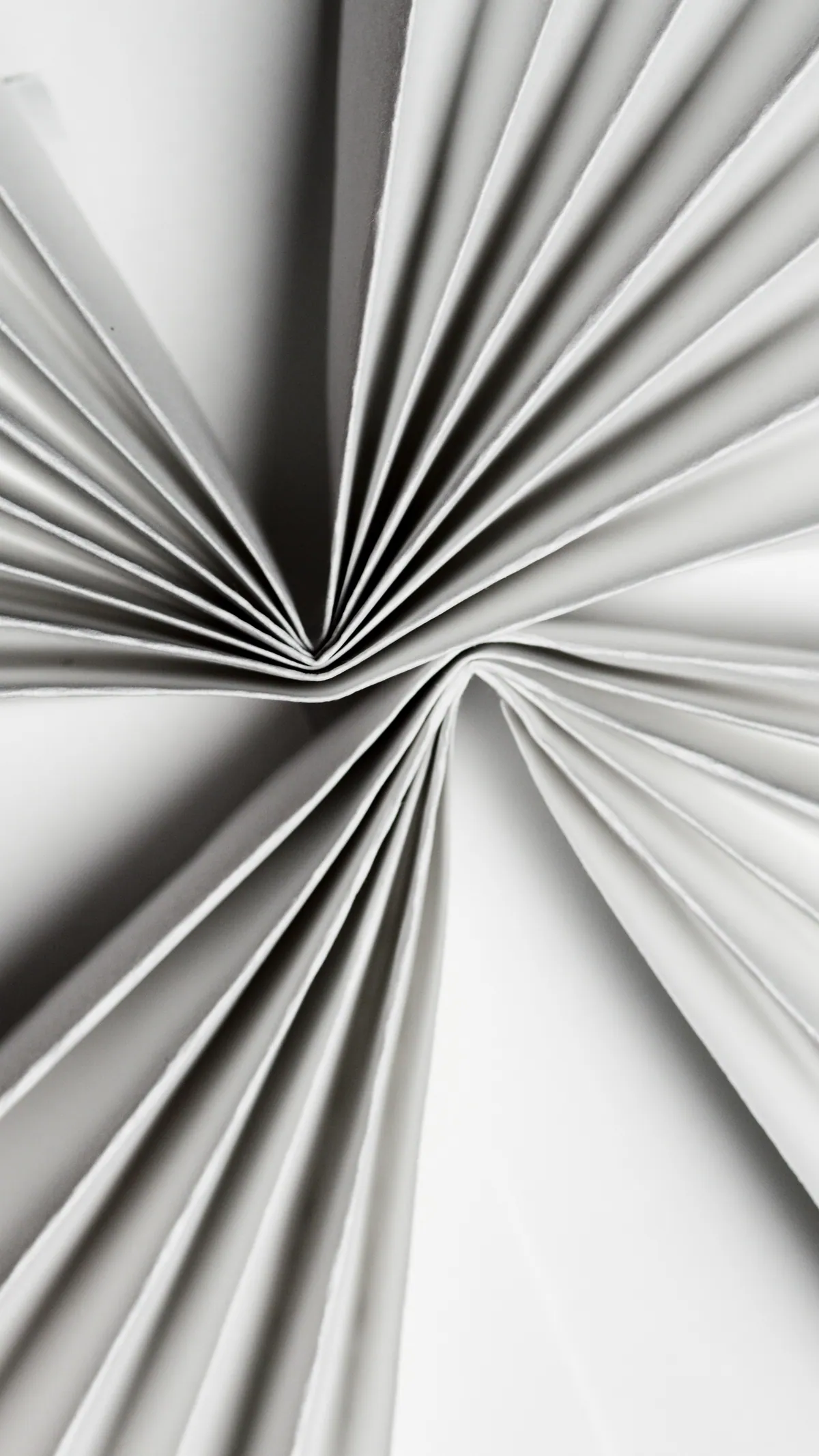 Two folded white paper forms meet along a sharply defined junction